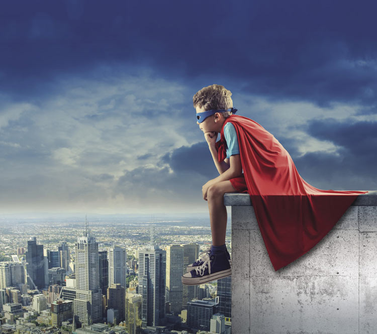 Young boy wearing a red cape and blue superhero mask, sitting on the edge of a skyscraper, looking out at the city below in a contemplative pose.